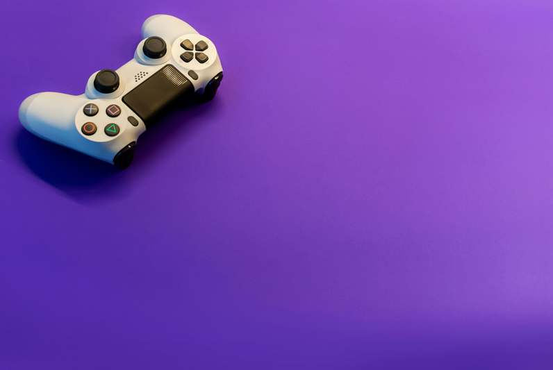Close-up of hands wearing VR gloves while holding Meta Quest 3 controllers, with visible motion tracking dots and soft studio lighting
